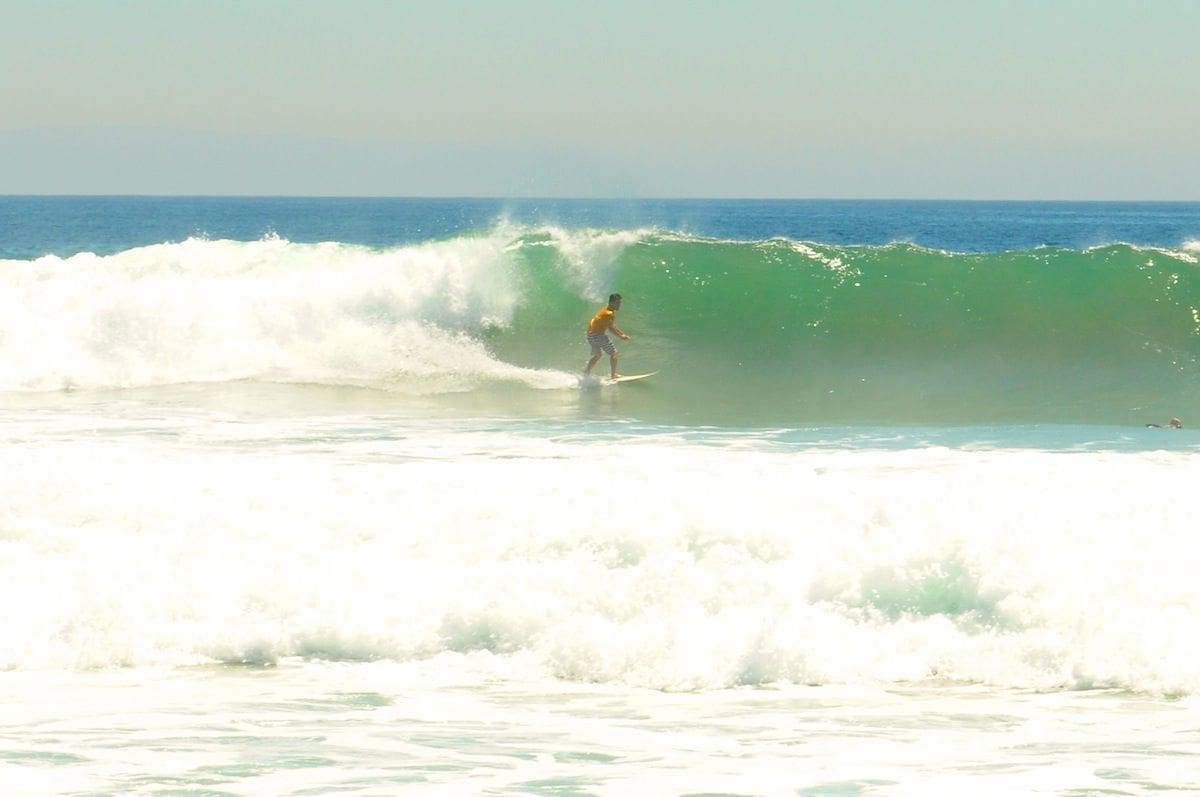 Surfer Riding Waves During High Surf Conditions