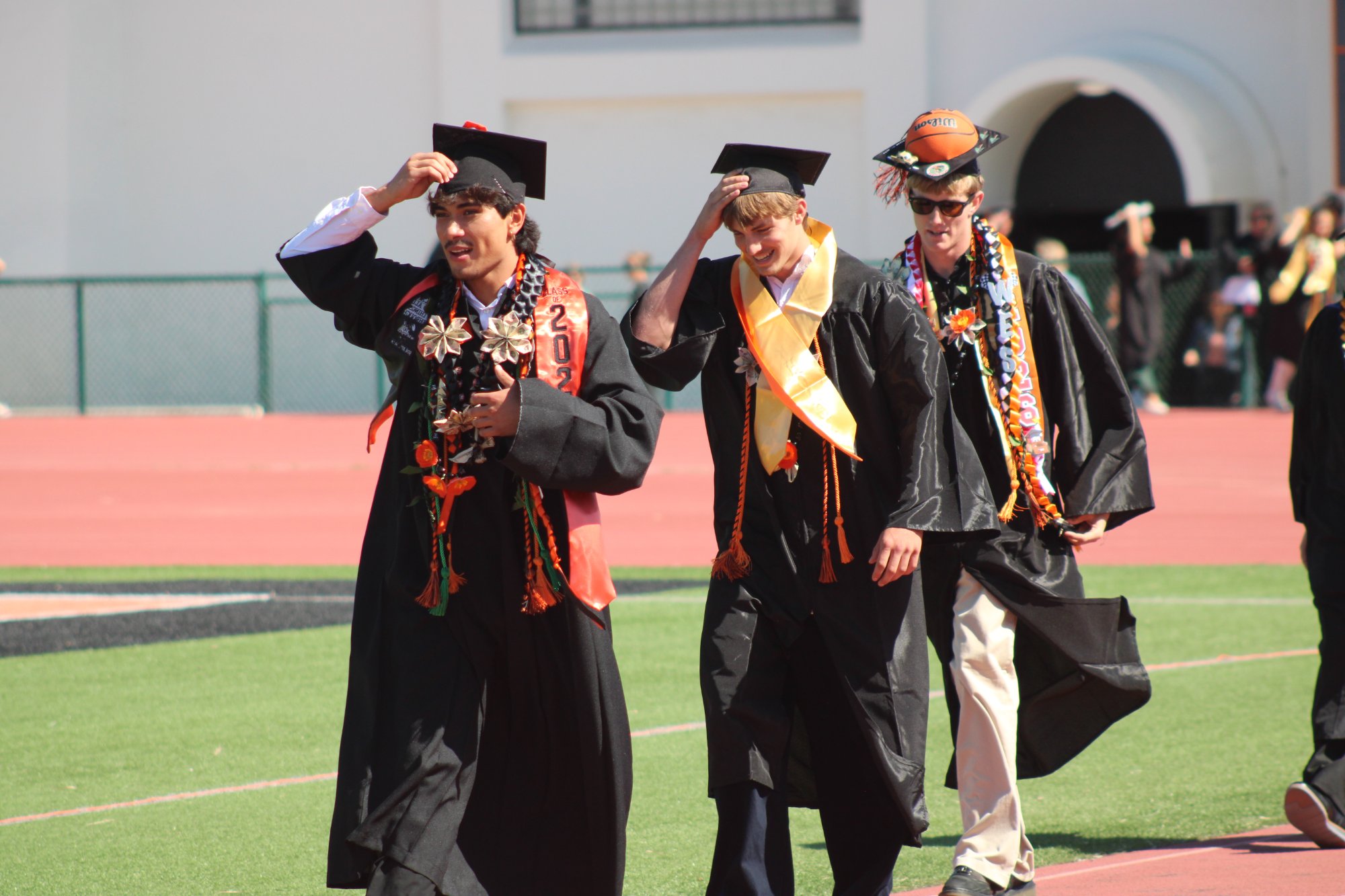 Santa Ynez High students make the walk from the campus gym to the staging area for the 2026 graduation ceremony Friday, May 29, at Rio Memorial Field. Many had to hold their mortarboards in place because of strong winds. Photo by Mike Chaldu/SYVS