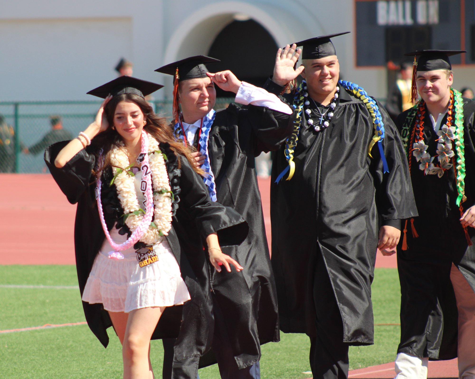 Santa Ynez High students make the walk from the campus gym to the staging area for the 2026 graduation ceremony Friday, May 29, at Rio Memorial Field. Many had to hold their mortarboards in place because of strong winds. Photo by Mike Chaldu/SYVS