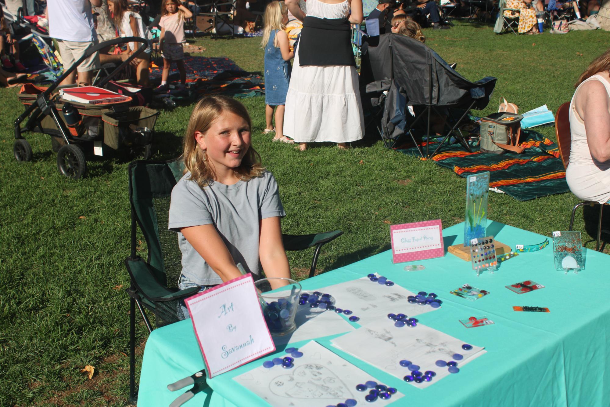 Savannah Maurer is shown at her table offering some of her sketches and fused-glass art projects at the Jr. Entrepreneur Fair on July 29 at Solvang Park. Photo by Mike Chaldu/SYVS